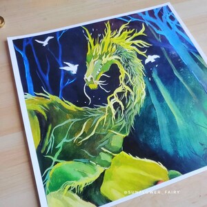 May include: A vibrant painting of a green dragon with yellow accents, set against a dark blue and green forest background. White birds are scattered throughout the scene. The artwork is signed "@SUNFLOWER_FAIRY".