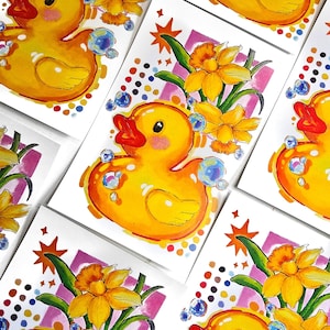 Puede incluir: Ilustraciones en acuarela de un patito de goma amarillo con pico rojo y mejillas rosas, rodeado de burbujas y narcisos amarillos. La obra de arte est&aacute; sobre tarjetas blancas con acentos coloridos, creando un tema alegre y juguet&oacute;n.