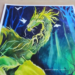 May include: A vibrant watercolor painting of a green dragon with yellow accents, set against a dark blue forest background. White birds fly in the sky. The artist's name, "SUNFLOWER_FAIRY," is visible in the lower right corner.
