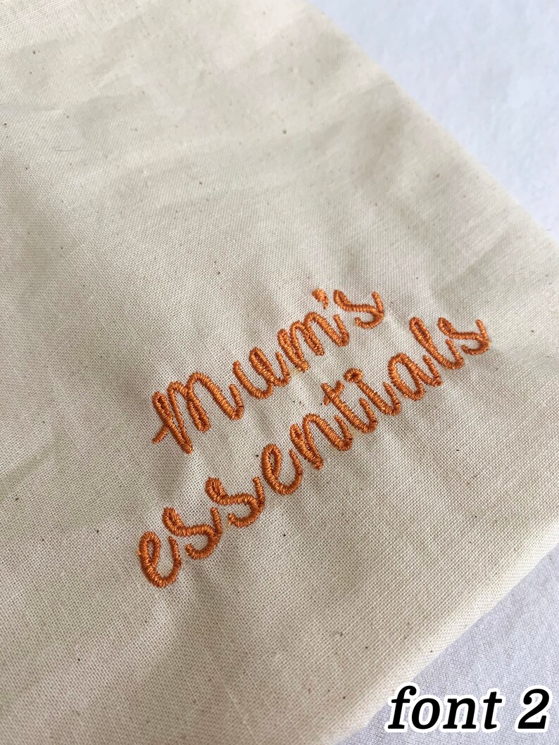 Puede incluir: Una bolsa de lona beige con el texto "Mummy's essentials" bordado en hilo naranja. El texto est&aacute; en una fuente cursiva.