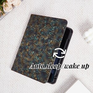 May include: A black leather tablet case with a dragonfly and floral pattern. The case has an auto sleep/wake up feature.