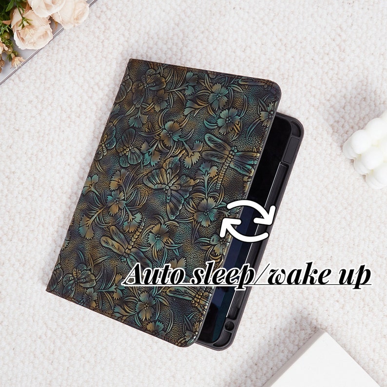 May include: A black leather tablet case with a dragonfly and floral pattern. The case has an auto sleep/wake up feature.