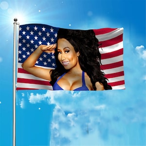 Peut inclure: Un drapeau avec le drapeau américain, avec une femme en haut bleu. La femme salue, sur fond de ciel bleu avec des nuages. Le drapeau est monté sur un poteau argenté.