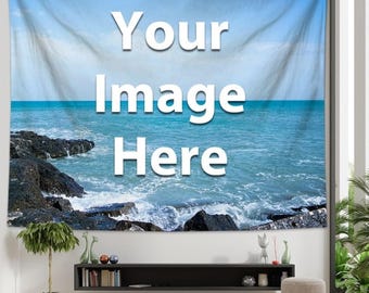 Könnte beinhalten: Eine große Wandtapisserie mit einer Meereslandschaft und dem Text "Your Image Here" in Weiß. Das Bild zeigt blaues Meer, Wellen und dunkle Felsen. Die Tapisserie wird in einem Wohnzimmer präsentiert.