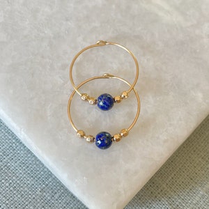 Lapis lazuli hoop earrings in gold and silver.