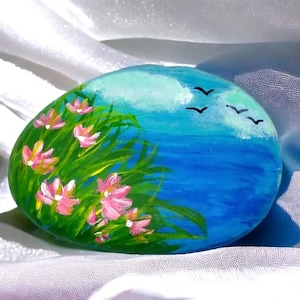 Handgeschilderde zeegezichtsteenkunst: kustdecor met roze bloemen