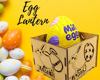 May include: A personalized wooden egg lantern with a bunny design and the name "JAMES" engraved on it. The lantern is holding a purple and yellow chocolate egg with the text "Mini Egg" on it.