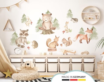 May include: Watercolor woodland animal wall decals featuring a bear, raccoon, fox, squirrel, rabbit, and hedgehog. The decals include trees and mushrooms. A wooden shelf holds toys and a clock. The words "MADE IN GERMANY" are at the bottom.