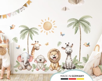 May include: A set of jungle animal wall decals featuring a giraffe, lion, zebra, and two elephants. The decals are surrounded by palm trees and a sun. The text "MADE IN GERMANY" is at the bottom of the image.