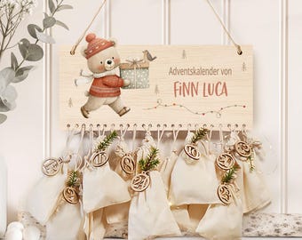 May include: Wooden advent calendar with a painted bear carrying a gift. The sign reads "Adventskalender von Finn Luca." Below, small cream-colored bags hang, each with a wooden number and greenery. A festive holiday decoration.