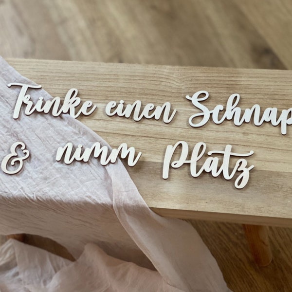 Schriftzug Trinke einen Schnaps und nimm Platz, aus Holz