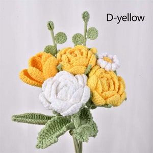 May include: A bouquet of crocheted flowers in shades of yellow and white. The bouquet includes roses, daisies, and other flower types. The flowers are arranged in a vase and have green crocheted leaves.