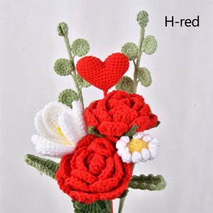 May include: A crocheted bouquet of red roses, a white flower, and a red heart. The bouquet is accented with green leaves. H-red.