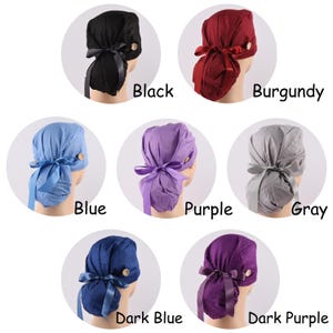 May include: A collection of seven scrub caps in black, burgundy, blue, purple, gray, dark blue, and dark purple. Each cap features a fabric tie at the back and a single wooden button on the side. The colors are labeled as Black, Burgundy, Blue, Purple, Gray, Dark Blue, and Dark Purple.