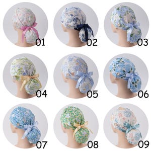 May include: A collection of nine scrub caps featuring various floral, botanical, and marine patterns. Each cap includes a side button for mask attachment and a coordinating satin ribbon tie at the back to secure the hair in a ponytail style.