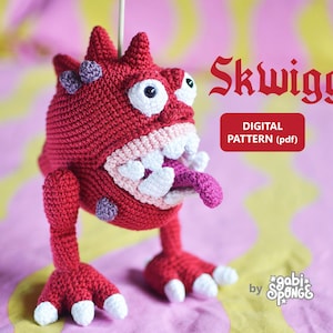May include: A crocheted red monster with a pink mouth, white teeth, and a purple tongue. The monster has a large, round body and four legs. The monster is named "Skwigg" and is a digital pattern (pdf).