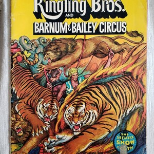 May include: A vintage souvenir program and magazine cover for Ringling Bros. and Barnum & Bailey Circus. The cover features illustrations of tigers, lions, and circus performers. The text reads "Ringling Bros. and Barnum & Bailey Circus" and "The Greatest Show on Earth."