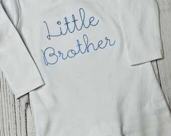 May include: White long-sleeve baby onesie with blue embroidered text that reads "little brother".