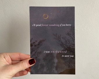 May include: A dark blue and purple postcard with a crescent moon and stars in the sky. The text on the postcard reads "I'll spend forever wondering if you knew I was enchanted to meet you."