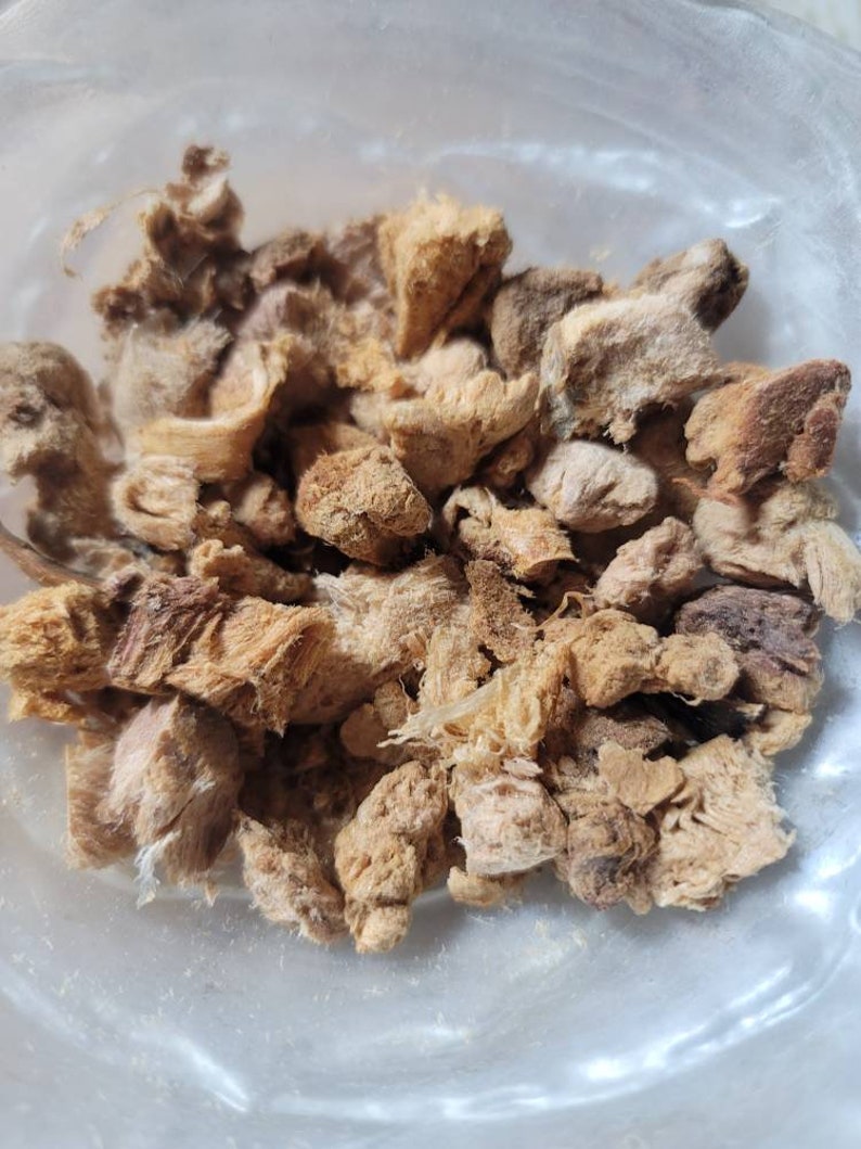 Puede incluir: Primer plano de un bol lleno de trozos de jengibre secos, de color marr&oacute;n claro y beige.