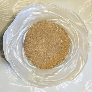 以下が含まれることがあります： 透明なガラスのボウルに、薄い茶色の粉末が満たされているクローズアップ。粉末はボウル全体に均等に分布している。