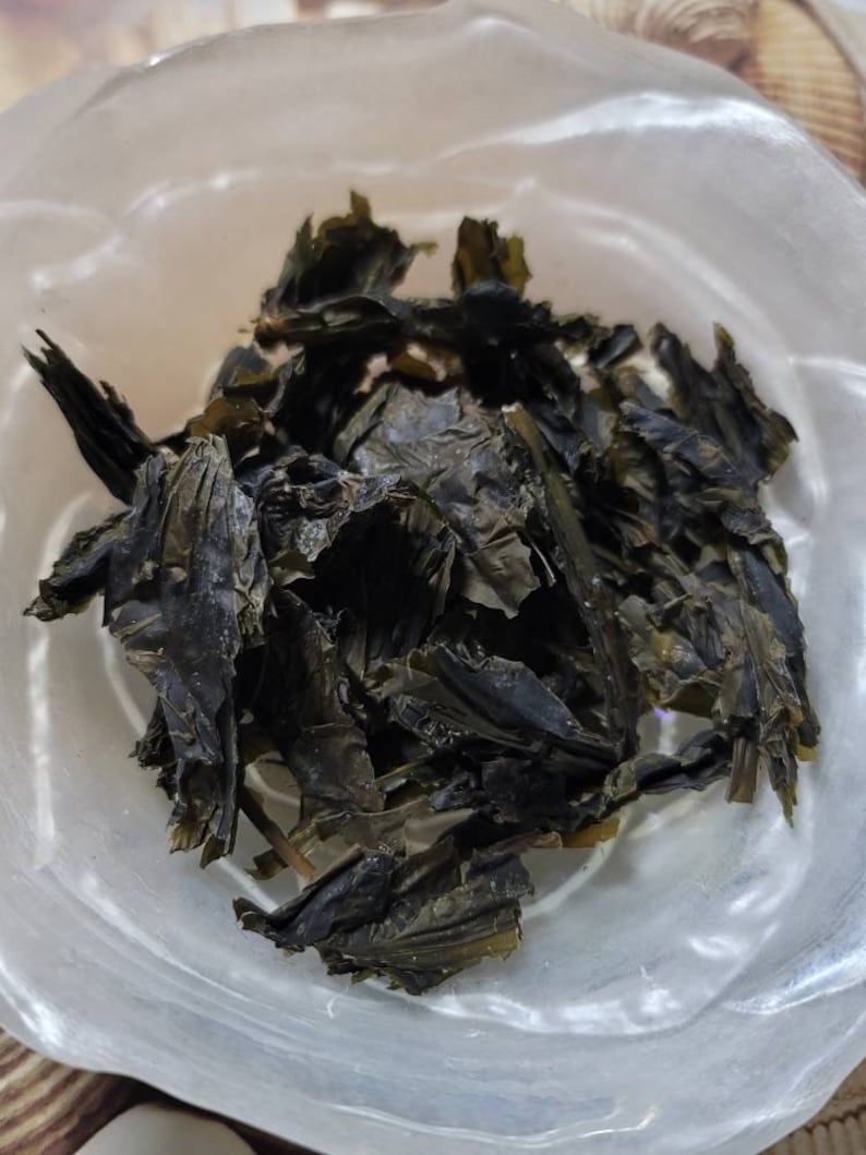 Puede incluir: Un bol de algas secas, de color verde oscuro, sobre un fondo marr&oacute;n claro.