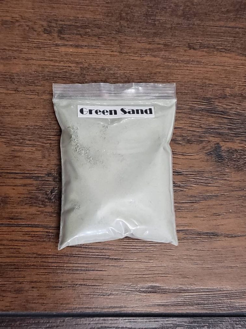 May include: A clear plastic bag filled with green sand. The bag has a label that says "Green Sand".