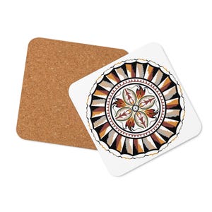 May include: A square white coaster with a detailed floral design in shades of brown, black, and orange. A second coaster made of cork is visible in the background. The design features a central flower and a patterned border.