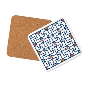 Puede incluir: Posavasos cuadrado con un patrón geométrico en azul marino, rojo, naranja y gris sobre fondo blanco. Un segundo posavasos de corcho está al lado. Los posavasos están diseñados para bebidas.