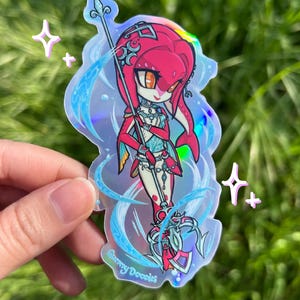 May include: Holographic sticker featuring a cartoon character with red hair and a spear. The character is wearing a red and blue outfit with intricate details. The sticker has a shiny, iridescent finish and the text "Sunny Doodles".