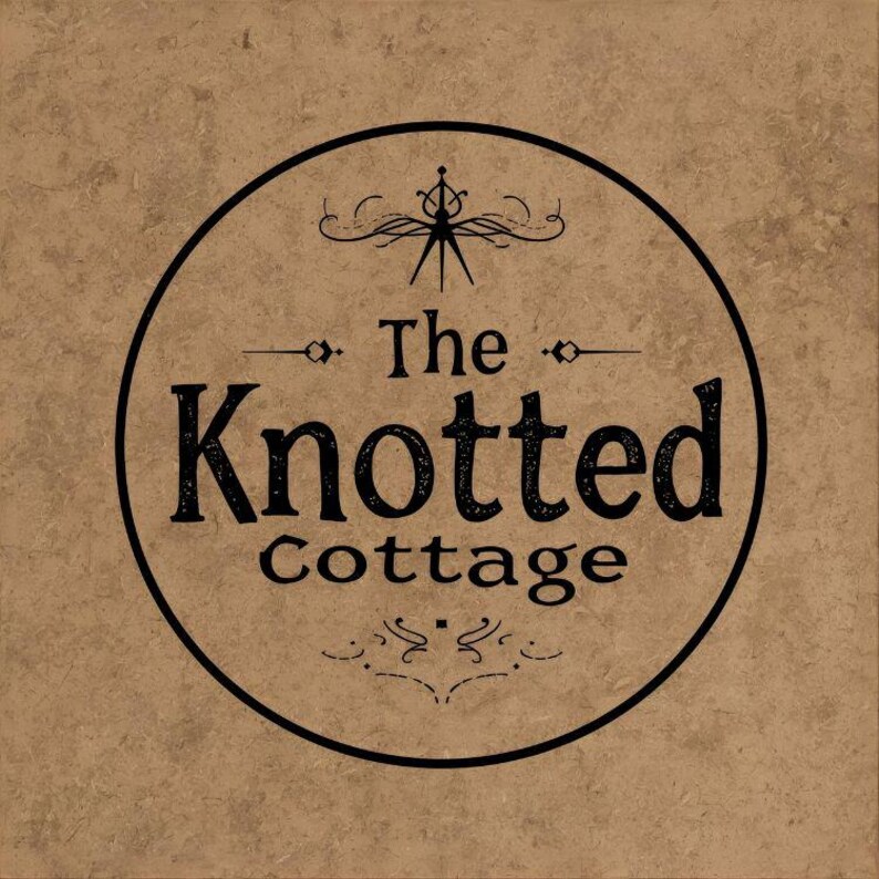 May include: A circular logo featuring the words "The Knotted Cottage" in a black, vintage font. The logo is set against a textured, tan background. Decorative flourishes and a stylized emblem are above and below the text.