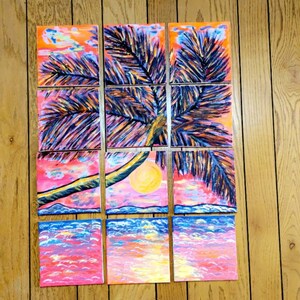 May include: A nine-piece painting set depicting a palm tree with a sunset and ocean scene. The painting is done in a vibrant color palette with shades of pink, orange, yellow, blue, and purple.