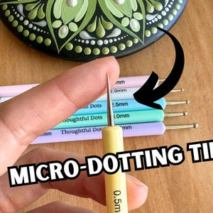 May include: A set of five dotting tools with different sized tips, ranging from 0.5mm to 2.5mm. The tools are made of metal and have a wooden handle. The tools are used for dotting art, such as mandala art.