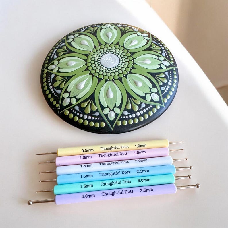 May include: A set of eight dotting tools for creating dot art, with different sizes ranging from 0.5mm to 4.0mm. The tools are color-coded and labeled with their size and the brand "Thoughtful Dots".