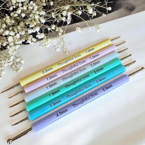 May include: Set of seven colorful dotting tools with different sized tips, ranging from 0.5mm to 4.0mm. The tools are labeled with their size and the brand "Thoughtful Dots".