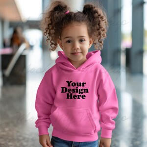 May include: A pink hooded sweatshirt with a black pocket and the text "Your Design Here" on the front.