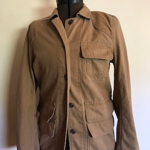 May include: A brown utility jacket with multiple pockets and button closures.