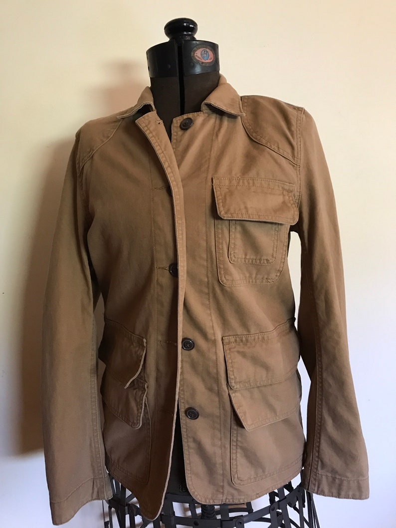 May include: A brown utility jacket with multiple pockets and button closures.