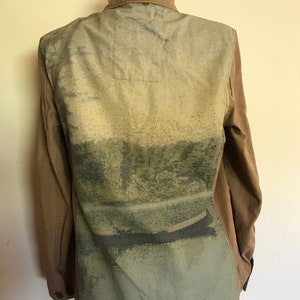 May include: A brown utility jacket with a green, blue, and white abstract print on the back.