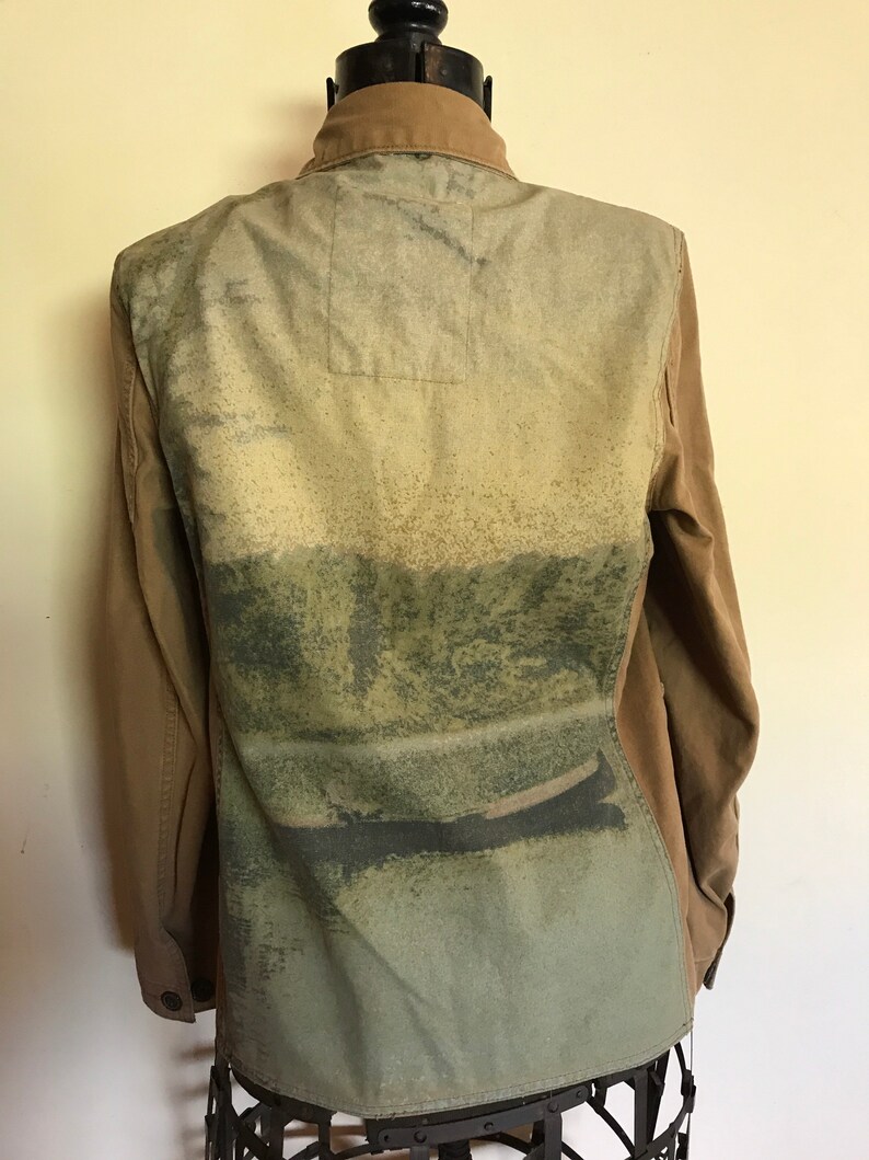 May include: A brown utility jacket with a green, blue, and white abstract print on the back.