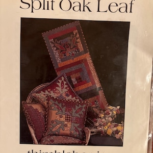 May include: A package for a quilting project titled "Split Oak Leaf" by Thimbleberries. The image shows a finished quilt and pillow set with a patchwork design in shades of red, blue, and brown. The package also includes the text "Sew Big Quilts".