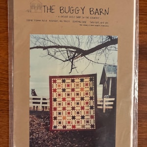 May include: A package for a quilt pattern titled "Circling the Ohios" from "The Buggy Barn." The pattern features a star design quilt, measuring 72 x 86 inches. The package is sealed in plastic.