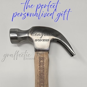 May include: A silver claw hammer with a wooden handle. The hammer head is engraved with "Congrats" and the date "11/05/2025". The handle is engraved with the name "KRUEGELS". The text "the perfect personalized gift" is in blue script.