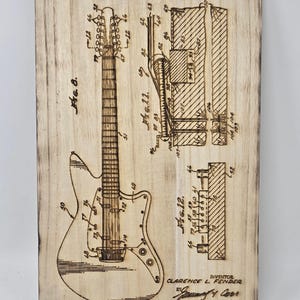 May include: A black and white line drawing of a guitar patent, showing the bridge construction for guitars. The patent is titled "Bridge Constructions for Guitars" and is dated December 13, 1966. The patent number is 3,290,980. The inventor is Clarence L. Fender.