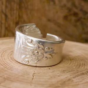 May include: A silver ring made from a repurposed spoon with a floral design.