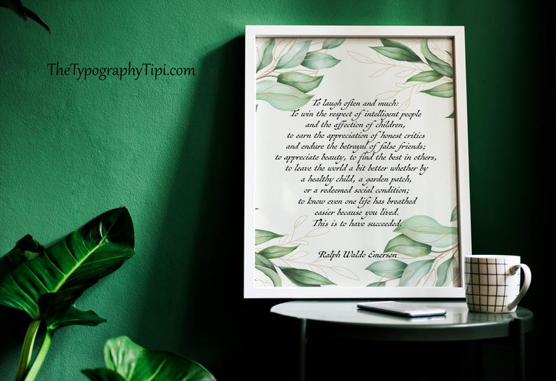 May include: A framed print with a quote by Ralph Waldo Emerson, featuring green leaf accents. A mug with a black grid pattern sits on a small table. The background is a dark green wall.