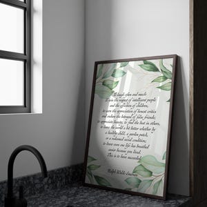 May include: A framed print with a brown border, featuring a quote by Ralph Waldo Emerson. The text is in a script font, with green leaf and gold accents. The print is leaning against a wall next to a window and a black faucet.