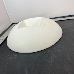 May include: A white ceramic bowl with a rounded shape and a small indentation in the centre.