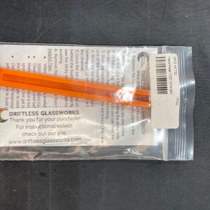 May include: A clear plastic bag containing an orange hand foiler tool and instructions. The tool is labeled "Hand Foiler 7/32" (Orange)" and the bag includes a "Driftless Glassworks" label with website information.