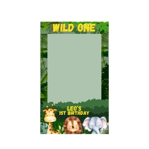 May include: A photo booth prop with a jungle theme. The top of the prop reads "WILD ONE" in yellow letters. The bottom features a giraffe, lion, and elephant. The text "LEO'S 1ST BIRTHDAY" is also included.